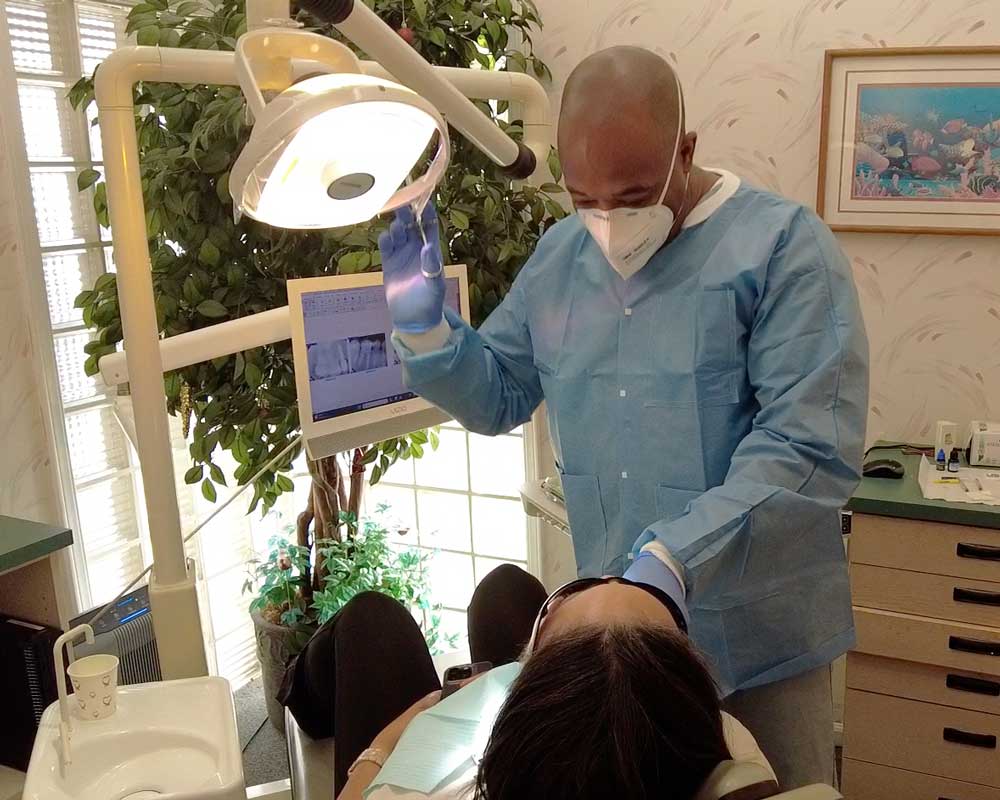 Whittier Palm Dental Dental Examination 50413 Dentist examining patient under light at Whittier Palm Dental in Montebello, CA